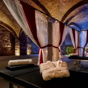 Sala de preparação com mesas de massagem, roupões e toalhas alinhadas, reflectindo a exclusividade e atenção aos detalhes do In Acqua Veritas Spa.
